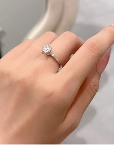 Close-up of a 1-carat moissanite ring on finger showing the brilliant round cut diamond