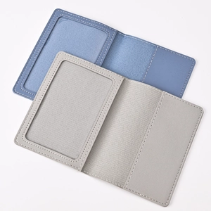 Detail view of open PU leather passport holder with ID card window and card slots in blue and grey