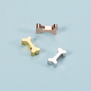 Three bone-shaped metal pet tags in rose gold, gold, and silver on a light blue background