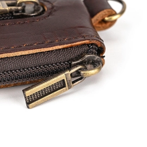 Detail of vintage brass zipper and heavy-duty stitching on crazy horse leather wallet
