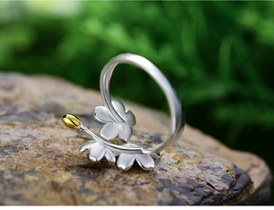 Detailed macro view of S925 sterling silver forget-me-not flower ring on natural rock