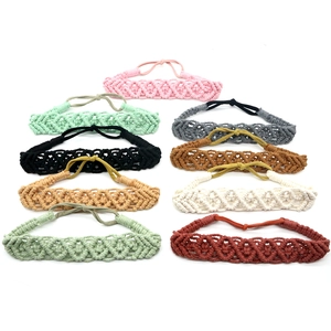 Detailed view of nine handmade braided cotton headbands in various colors on white background
