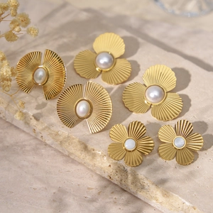 Trois paires de boucles d'oreilles vintage dorées avec perles sur pierre de travertin