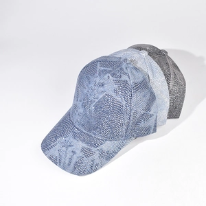 Detailed close-up of three sparkling rhinestone-studded baseball caps in denim and grey