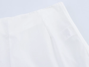 Détail de la broderie ajourée et des coutures sur l'ensemble en coton blanc