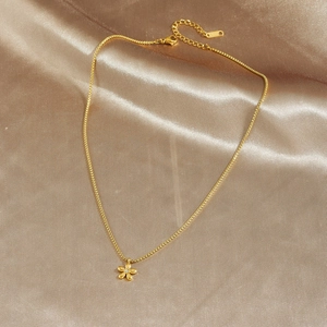 Minimalist gold plated stainless steel flower pendant necklace on silk background