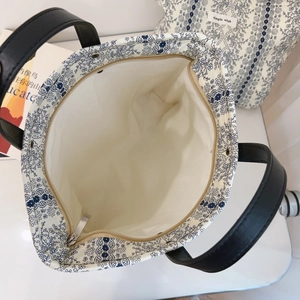 Top view of blue floral cotton tote bag with metal zipper and matching storage pouch