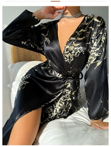 Detail of elegant black floral satin robe with V-neck wrap and premium glossy texture