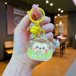 Detail of yellow shiba inu keychain with oil-filled liquid glitter and bell charm