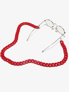 Macro shot of candy red acrylic chunky chain lanyard attached to vintage gold round glasses