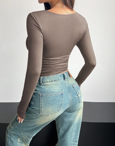 Rear view of tight-fitting brown long sleeve top and distressed light blue jeans
