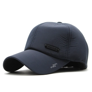Detail of dark blue waterproof baseball cap with metal men's tag and sports printing