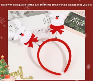 Detail of Christmas reindeer spring headband with red bows and plush decorations