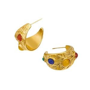 Vintage gold earrings with colorful stones and leaf texture in a classic studio shot