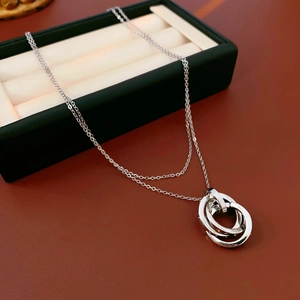 Close-up of interlocking silver triple rings with brilliant metallic finish and cubic zirconia