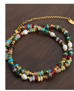 Macro detail of bohemian beaded bracelet with freshwater pearls and colorful stones