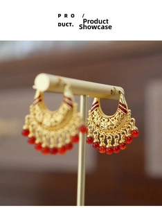 Detailed macro view of Chinese style red tassel earrings with hollow golden floral design