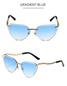 Detail view of cat eye sunglasses featuring gradient blue lenses and gold wavy metal temples