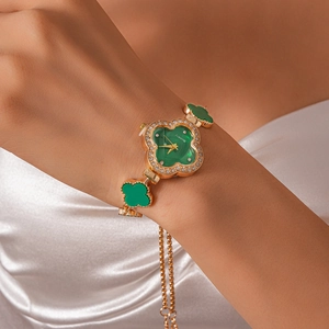 Elegant gold flower watch with green clover dial and sparkling rhinestones on the wrist