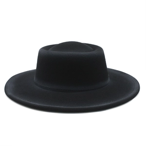 Close-up of the stiff brim and fine stitching on a black wool felt flat top hat