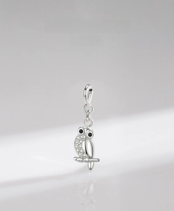 Macro detail of 925 sterling silver owl pendant with white pavé cubic zirconia
