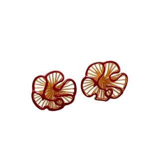 Elegant gold-plated flower stud earrings with red enamel detailing on a white background