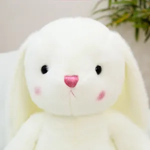 Close-up of white plush bunny with pink heart embroidery and soft fur texture