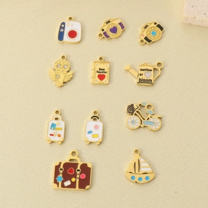 Detailed view of assorted gold enamel pendants including camera, microphone and sailboat