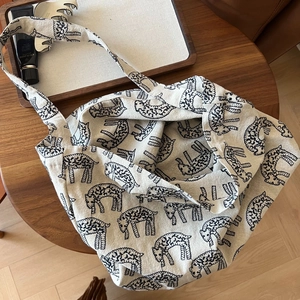 Close-up of canvas tote bag featuring minimalist black sheep embroidery on cream fabric
