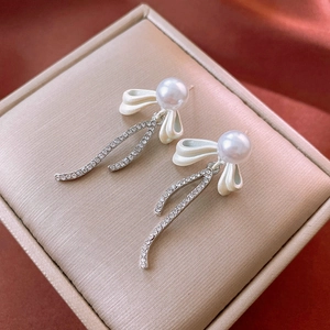 Elegant silver bow earrings with faux pearls and sparkling diamond-set tassels