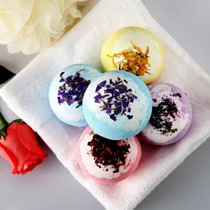 Coffret de boules de bain artisanales aux fleurs séchées sur serviette blanche spa