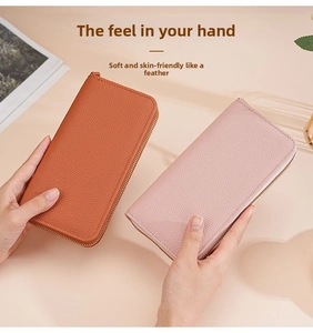 Detail of long litchi pattern wallets in orange and pink with gold zippers