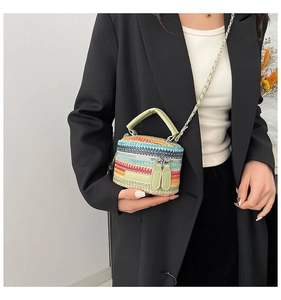Dettaglio di una mini borsa a secchiello in tessuto colorato con texture a righe e tracolla