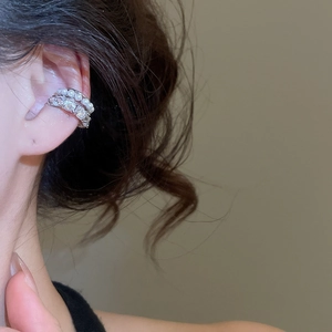 Detail of multi-layer ear cuff featuring white pearls and cubic zirconia on silver base