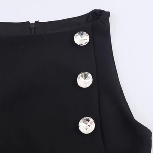 Detail of black fabric featuring three large rhinestone buttons and an invisible side zipper