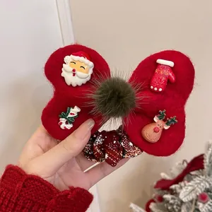Detail of Christmas bow hair scrunchie with plush pom-poms and festive charms