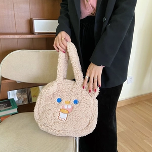 Beige faux shearling tote bag with bear embroidery held by a model in casual attire
