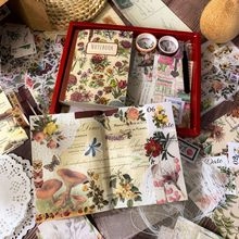 Vista de detalle de un set de papelería floral vintage con cuaderno y cintas adhesivas