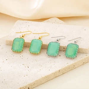Detailed macro view of green rectangular stones in gold and silver steel hook settings