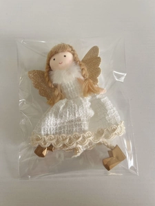 Détail d'une poupée ange avec ailes dorées et robe blanche à paillettes sous emballage