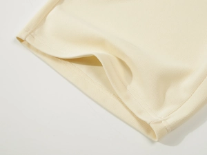 Macro detail of the cream rib-knit fabric and high-quality stitching on the athletic shorts