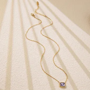 Detail of gold chain necklace featuring a purple rectangular gemstone and lobster clasp