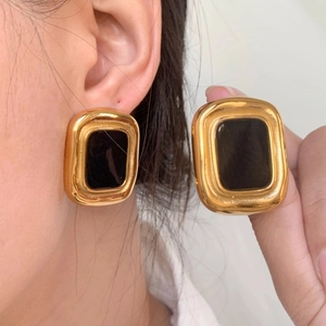 Nahaufnahme von Vintage-Ohrsteckern mit schwarzem Achat und goldenem Metallrahmen