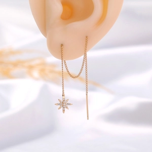 Detail of long tassel earrings with a sparkling zircon star pendant on a model