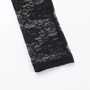 Détail en gros plan des motifs floraux en dentelle noire sur une robe de soirée chic
