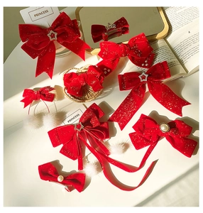 Detailed set of red velvet bow hair accessories with white pom-poms and pearls