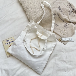 Close-up of white canvas tote bag with drawstring closure and thick fabric texture