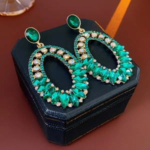 Close-up of vintage emerald green oval earrings with crystal rhinestones in a gift box