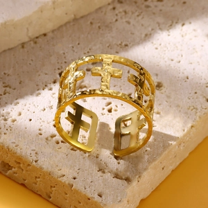 Detailed close-up of a wide gold-plated stainless steel ring with cutout cross patterns