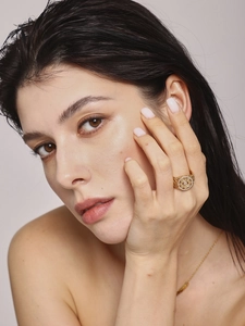 Detailed view of luxury gold hollow geometric ring with diamonds on model's hand